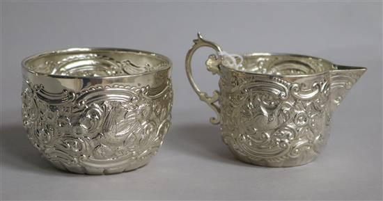 A late Victorian embossed silver cream jug and sugar bowl, Goldsmiths & Silversmiths Co, London, 1894, 4.5 oz.